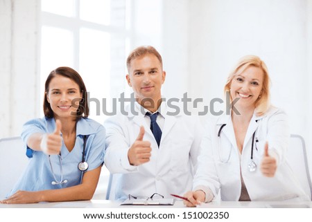 healthcare and medical concept - group of doctors on a meeting showing thumbs up
