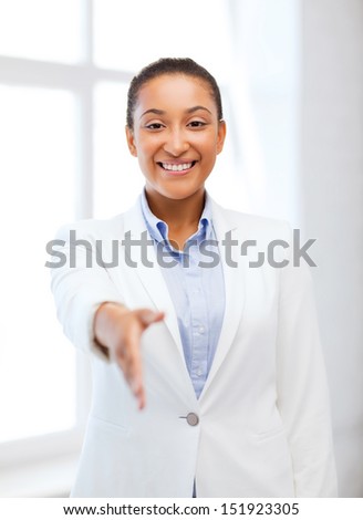 business and education concept - african businesswoman with an open hand ready for handshake