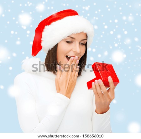 christmas, x-mas, winter, happiness concept - surprised woman in santa helper hat with small gift box