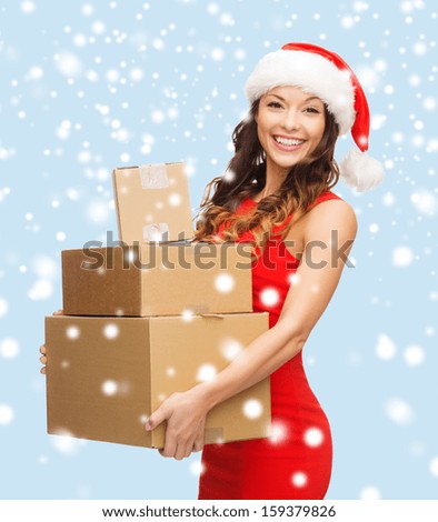 christmas, x-mas, winter, happiness concept - smiling woman in santa helper hat with many parcel boxes