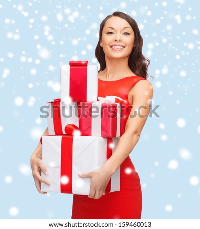 christmas, x-mas, valentine\'s day, celebration concept - smiling woman in red dress with many gift boxes