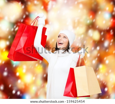 retail and sale concept - happy woman in winter clothes with shopping bags