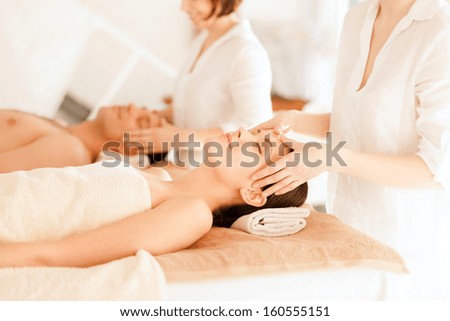 health and beauty, resort and relaxation concept - couple in spa salon getting facial massage