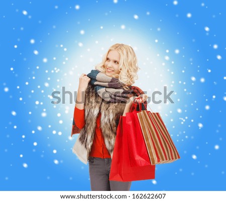 retail and sale concept - happy teenage girl in winter clothes with shopping bags