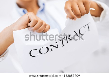 business, documents, legal and real estate concept - picture of woman hands tearing contract paper