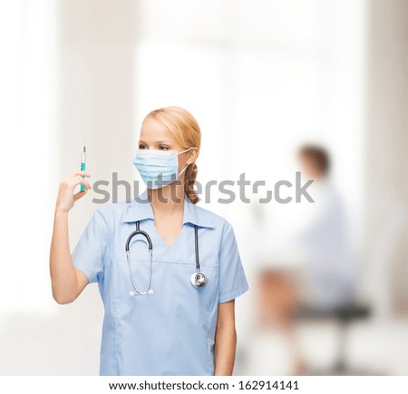 healthcare and medical concept - female doctor or nurse in medical mask holding syringe with injection