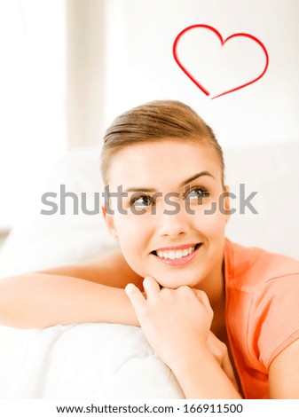 happiness and love concept - smiling woman lying on the couch and dreaming