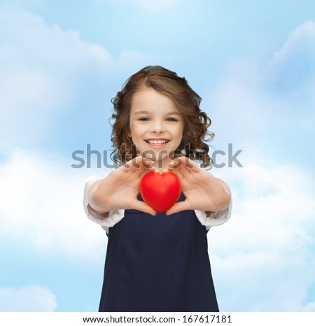 love, children and happiness concept - beautiful girl with small heart