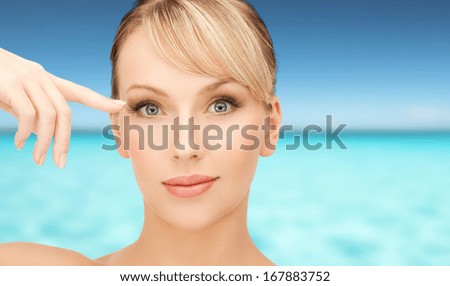 health, spa, beauty and vacation concept - face of beautiful woman touching her eye area