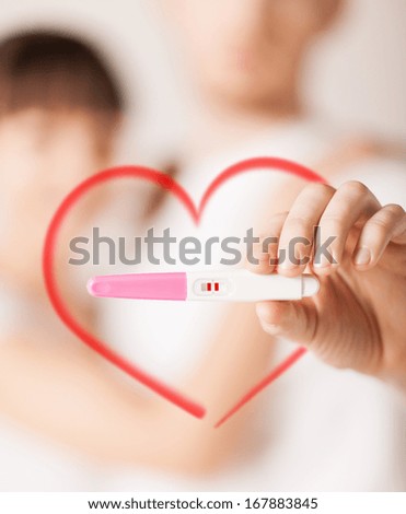 couple, pregnancy and love concept - close up of woman and man hands with pregnancy test