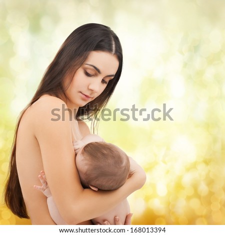 family, children, parenthood and happiness concept - happy mother feeding her adorable baby