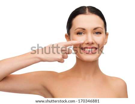 health, spa and beauty concept - clean face of beautiful young woman pointing to her cheek