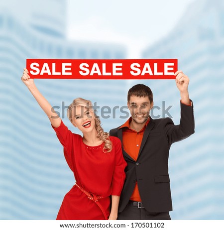 shopping, sale,christmas, couple and x-mas concept - smiling woman and man with red sale sign outdoors