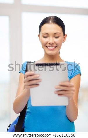 education, technology, communication and school concept - smiling female student with tablet pc and bag at school