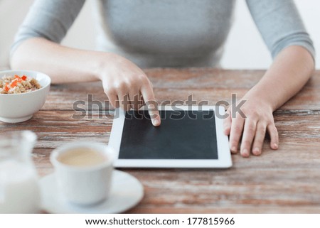 health, technology, internet, food and home concept - close up of woman pointing finger to tablet pc computer screen