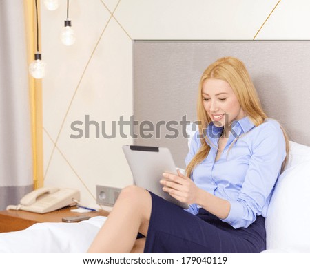 business, technology, internet and hotel concept - happy businesswoman with tablet pc computer lying in hotel in bed