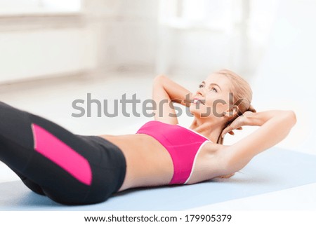 fitness and exercise concept - beautiful sporty woman doing exercise on the floor