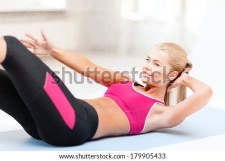 fitness and exercise concept - beautiful sporty woman doing exercise on the floor