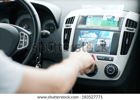 transportation and vehicle concept - man using car control panel to read news