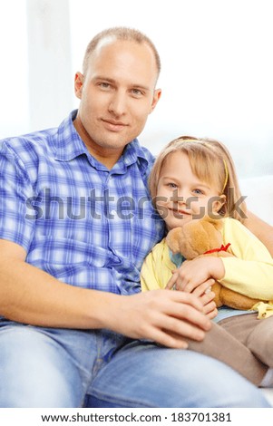 family, child and happiness concept - smiling father and daughter with teddy bear at home