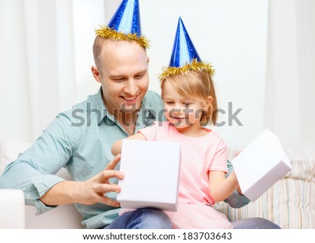 family, children, celebration, holidays, birthday and happy people concept - happy father and daughter in blue party hats with gift box