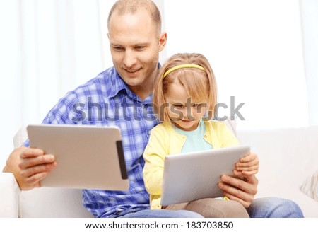 family, children, parenthood, technology and internet concept - happy father and daughter with tablet pc computer at home