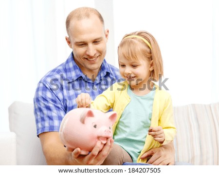 family, children, money, investment and happy people concept - happy father and daughter with big pink piggy bank