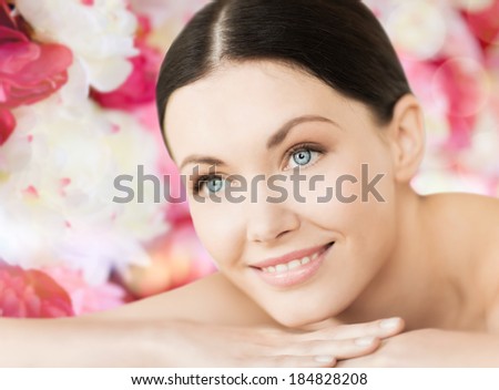 spa and beauty concept - smiling woman in spa salon lying on the massage desk