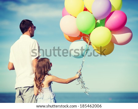 summer holidays, celebration, children and family concept - father and daughter with colorful balloons