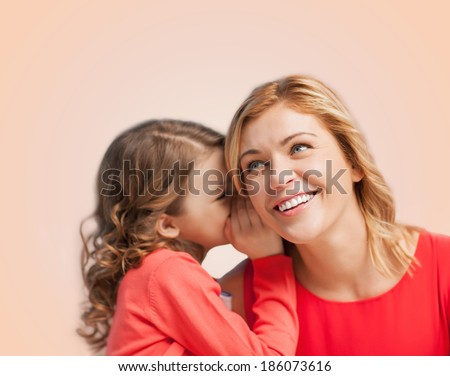 family, child and happiness concept - smiling mother and daughter whispering gossip