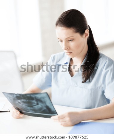 healthcare, medical and radiology concept - female doctor or dentist looking at x-ray