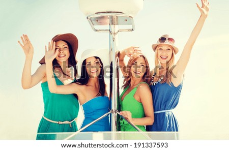 summer holidays and vacation concept - girls waving on boat or yacht