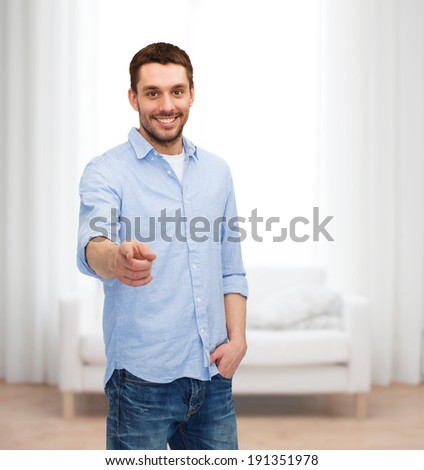 happiness and people concept - smiling man pointing finger at you