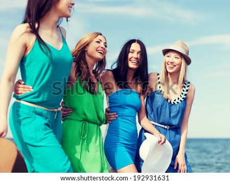 summer holidays and vacation concept - girls walking on the beach