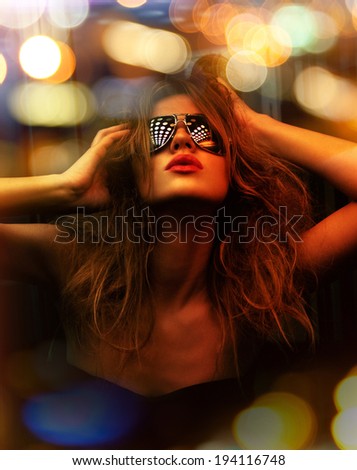 dark color toned picture of fashionable woman in nightclub