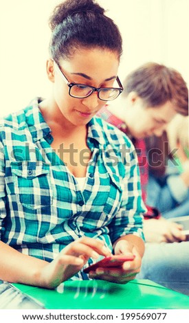 education concept - smiling international student girl with smartphone at school