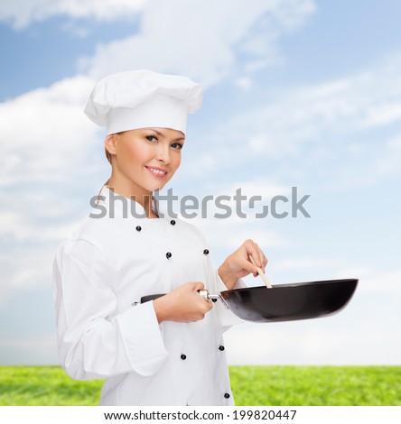 cooking and food concept - smiling female chef, cook or baker with pan and spoon