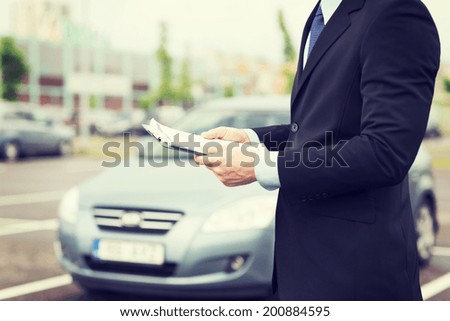 transportation and ownership concept - man with car documents outside