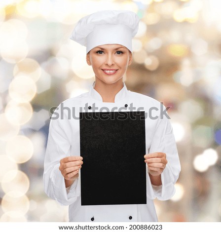 cooking, advertisement and food concept - smiling female chef, cook or baker with blank black paper
