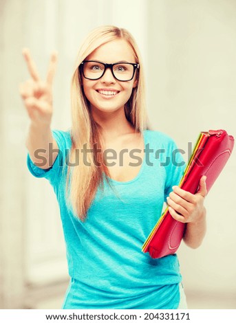 education and school concept - smiling student with folders showing victory or peace sign
