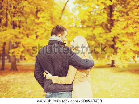holidays, love, travel, tourism, relationship and dating concept - romantic couple kissing in the autumn park
