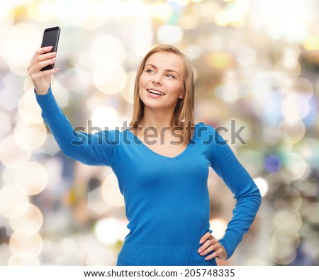technology and internet concept - smiling woman taking self picture with smartphone camera