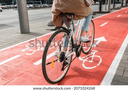 traffic, city transport and people concept - close up of woman cycling along red bike lane with signs of bicycles and two way arrows on street Photo stock © 