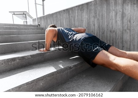 fitness, sport and training concept - young man doing push ups on stairs outdoors Foto stock © 