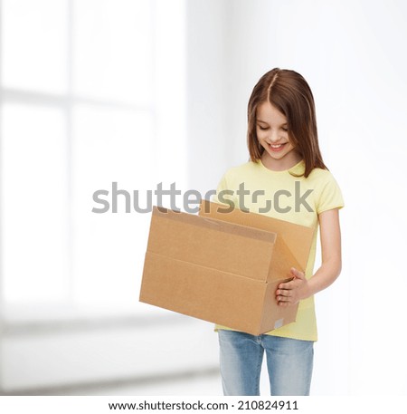 advertising, childhood, delivery, mail and people - smiling girl holding open cardboard box and looking into it over white room background