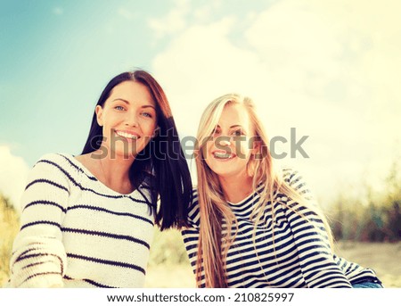 summer, holidays, vacation, happy people concept - smiling girlfriends having fun on the beach