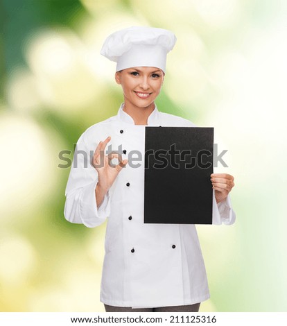 cooking, advertisement and food concept - smiling female chef, cook or baker with blank black paper showing ok sing