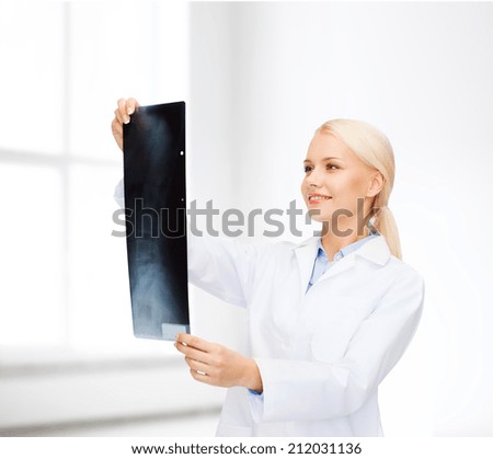 healthcare, medicine and radiology concept - smiling female doctor looking at x-ray over white room background