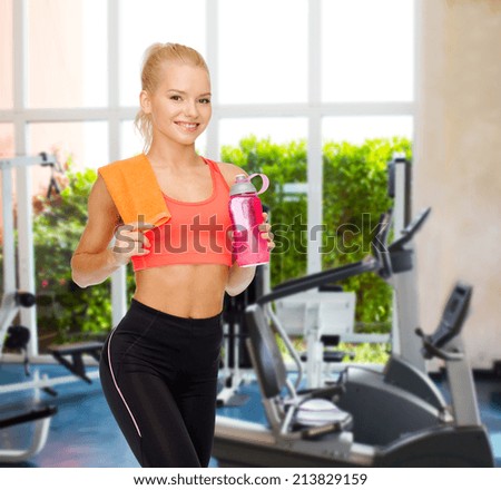 sport, exercise and healthcare concept - sporty woman with orange towel and water bottle
