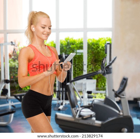 sport, fitness, technology, internet and healthcare concept - smiling sporty woman with smartphone and earphones